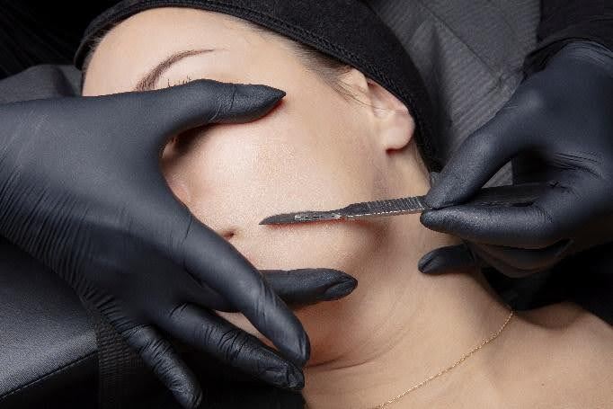 Hispanic man receiving a deep cleansing facial focused on congested pores in a medical spa